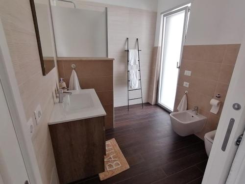a bathroom with a sink and a toilet and a mirror at La Dimora del Cuore - U1598 in Olbia