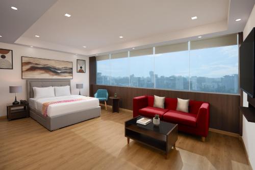 a hotel room with a bed and a red chair at Ginger Gurugram, Sector 1 in Gurgaon