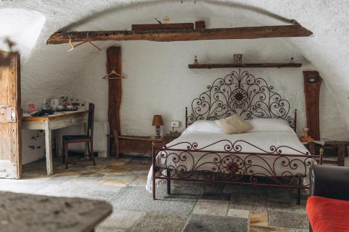 a bedroom with a bed and a desk in a room at Agribenessere Agli Abatti in Barge