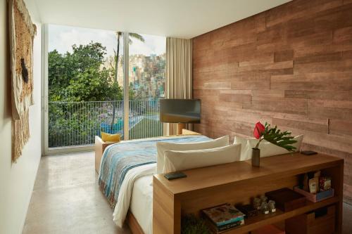a bedroom with a bed and a large window at Desa Potato Head Bali in Seminyak