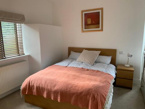 a bedroom with a bed with a orange blanket at Howth Village Apartment 2 in Dublin