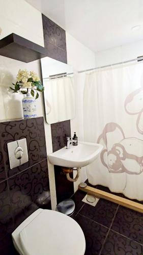 a bathroom with a toilet sink and a monkey shower curtain at Farayayellowstone 1 bedroom with panoramic mountain view fit 4 in Bayn an Nuhūr