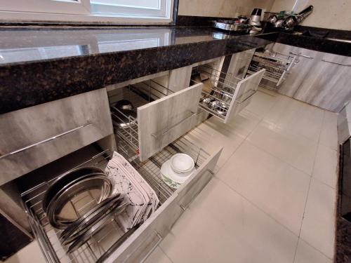 a kitchen with an open dishwasher in a counter at Sublime Homestay in Bhubaneshwar
