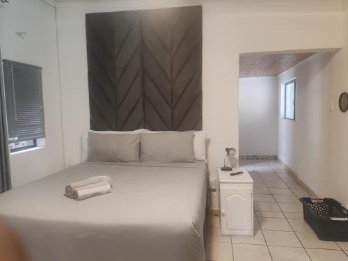 a bedroom with a large white bed and a telephone at Kahunaz in Vereeniging