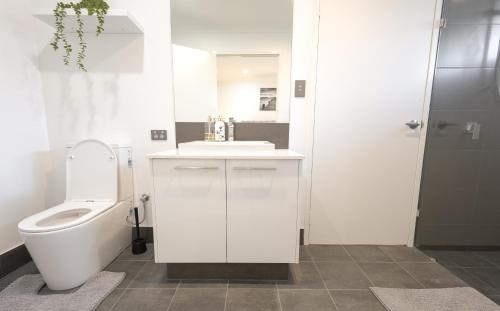 a white bathroom with a toilet and a sink at Shipwreck Park Villas in Westfield