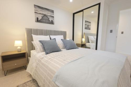 a bedroom with a large white bed with blue pillows at Shipwreck Park Villas in Westfield