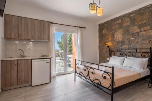 a bedroom with a bed and a stone wall at Katerina View in Mikonos