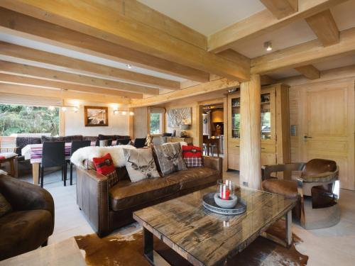 a living room with a couch and a table at Chalet 4★, 11 pers, 6 ch, terrasse sud, animaux admis - FR-1-304-21 in La Clusaz