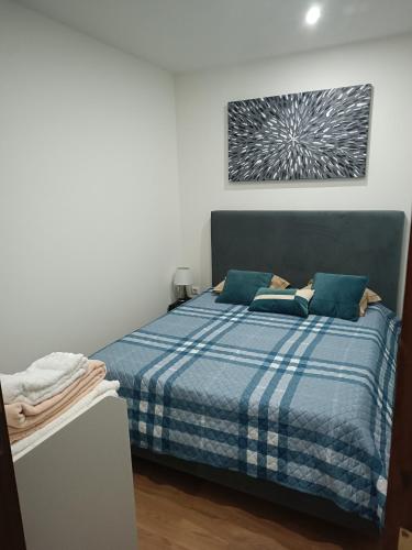 a bedroom with a bed with a blue plaid blanket at Parkofir in Fão