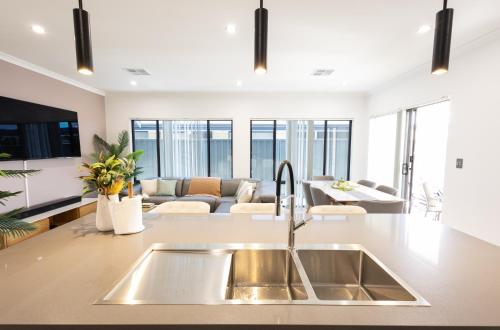 a kitchen with a sink and a living room at Shipwreck Park Villas in Westfield