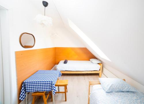 a attic bedroom with two beds and a table at Hostel Jamnik in Psary