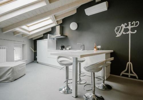 a kitchen with a sink and stools in a room at Casa Felice by Villa Porta Collection in Luino