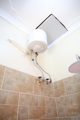 a shower with a light in a bathroom at Simbego Cottages Lira in Lira
