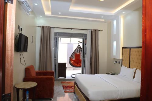 a hotel room with a bed and a chair at Simbego Cottages Lira in Lira