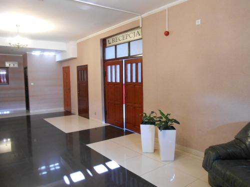 a lobby with two potted plants in a building at Hotel Lubavia in Lubawka