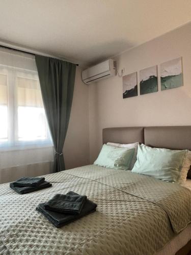 a bedroom with a bed with two towels on it at Apartman Panorama in Temerin