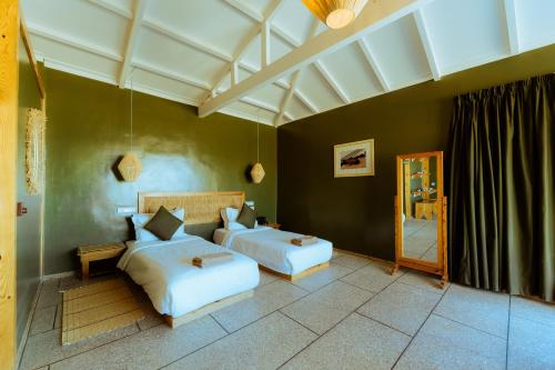 a bedroom with two beds and a mirror at Oasis212 Dakhla in Dakhla