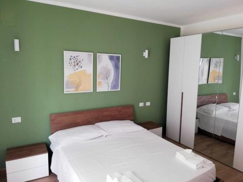 a bedroom with a white bed and a green wall at La Dimora del Cuore - U1598 in Olbia