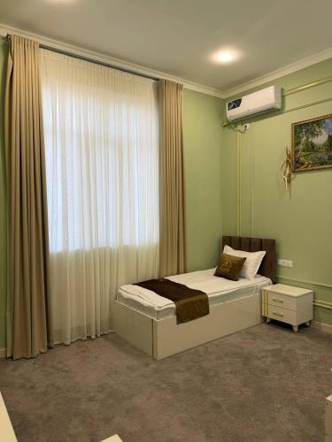 a bedroom with a bed and a window at The Avenue Hotel in Kogon