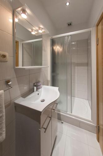a white bathroom with a sink and a shower at Villa Klara Guest House in Baška Voda