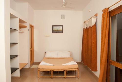 a small room with a bed and a window at The Mountain Retreat in Tiruvannāmalai