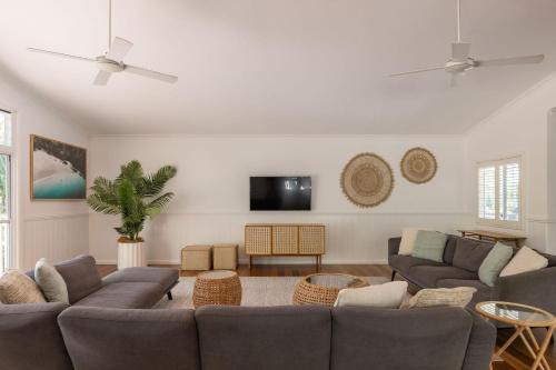 a living room with couches and a flat screen tv at Sunrise Guesthouse in Byron Bay