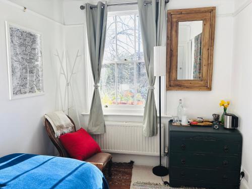 a bedroom with a bed and a dresser and a window at Central Victorian House in London