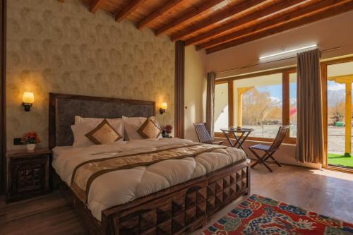 a bedroom with a large bed and a table at The Walnut Inn Resort in Hundar