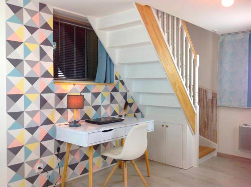 un bureau avec un bureau et un mur géométrique dans l'établissement Appartement sur 3 niveaux centre ville CAEN, à Caen