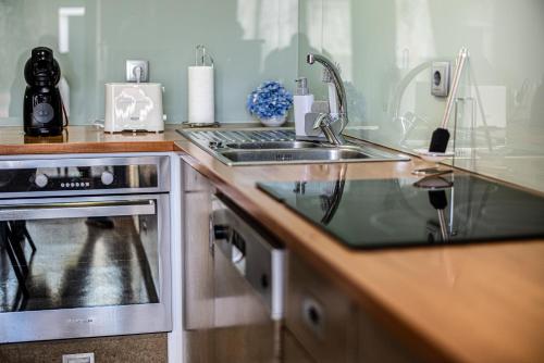 a kitchen with a sink and a stove at Porta 29 in Vila Franca do Campo