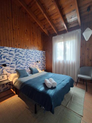 a bedroom with a large bed with two towels on it at Casa de Madera I - Naturaleza y Experiencias in Bicorp