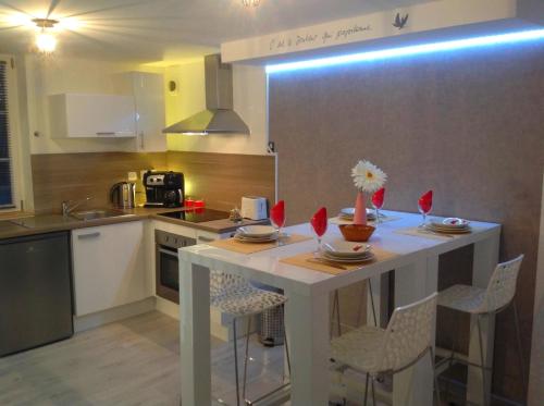 una cucina con tavolo e sedie bianchi di Appartement sur 3 niveaux centre ville CAEN a Caen