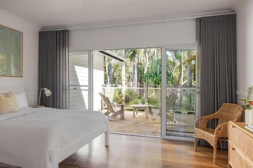 a bedroom with a bed and a sliding glass door at Sunrise Guesthouse in Byron Bay