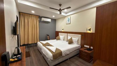 a bedroom with a large bed and a television at Hotel La Hotera in Hyderabad