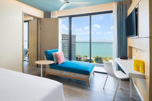 a hotel room with a bed and a view of the ocean at OZO North Pattaya in Pattaya