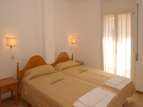 a bedroom with two beds and a window at Apartment Empuriabrava by Beach & Canals in Empuriabrava