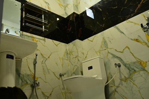 a bathroom with a toilet and a sink at Hotel Parineeta in Khagaria
