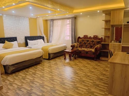a hotel room with two beds and a couch at Amboseli Gateway Hotel in Kimana