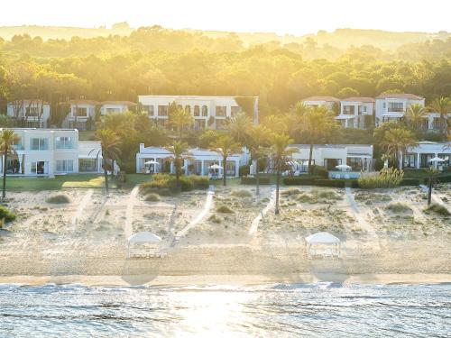 an aerial view of a beach with houses and palm trees at Mandola Rosa, A Resort to Live in Loutra Killinis