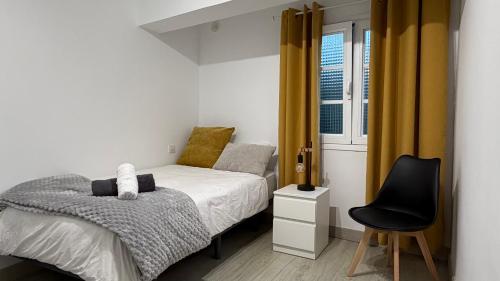 a small bedroom with a bed and a chair at Casa Calma III in Tacoronte