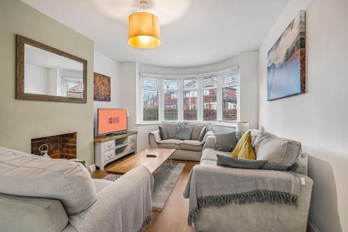 a living room with two couches and a tv at GuestReady - Tranquil Retreat near Bramall Hall in Cheadle