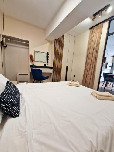 a large white bed in a room with a window at By The Pool Apartments #7 in Velingrad