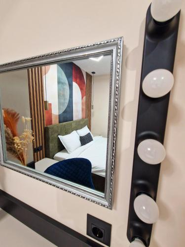 a mirror on a wall with a bed in a room at By The Pool Apartments #7 in Velingrad