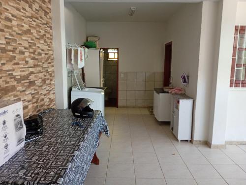 a room with a kitchen with a counter and a refrigerator at Casa 4 Quartos garagem 3 carros, churrasqueira e ar condicionado, in São José