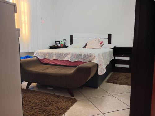 a bedroom with a bed and a chair at Casa 4 Quartos garagem 3 carros, churrasqueira e ar condicionado, in São José
