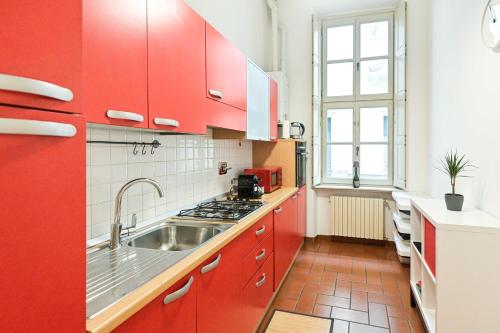 a kitchen with red cabinets and a sink at Top Living Apartments - De Lellis Torino Centro in Turin
