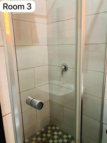 a shower with a glass door with a floor at The Bright Guest House in Pretoria