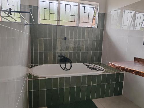 a bathroom with a bath tub and a sink at Boh- House in Graskop