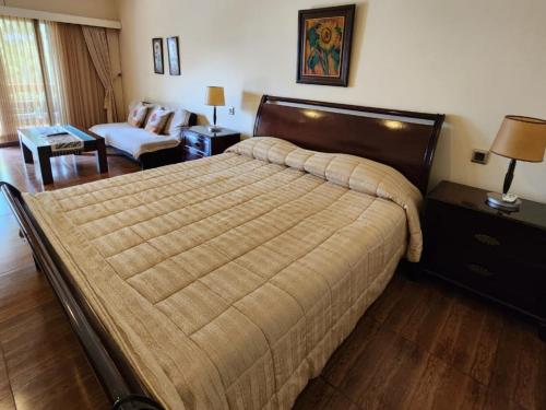 a bedroom with a large bed and a living room at Kulem Cisitu in Bandung