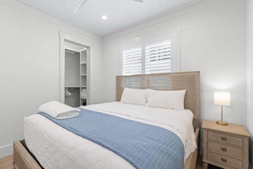 a white bedroom with a bed with a blue blanket at 26 Blue Coast Ct in Inlet Beach